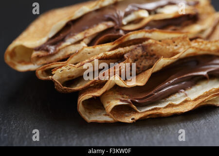 dünne Crepes oder Blinis mit Schokoladencreme Stockfoto