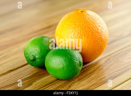 Zwei Limetten und eine Orange rustikalen Hintergrund Stockfoto