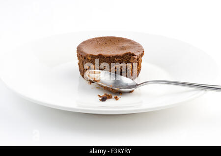 Halb gegessen leckeren Schokoladenkuchen-Muffin mit schmutzigen Löffel Stockfoto