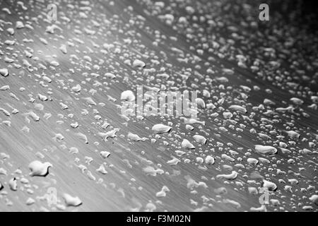 Edelstahl-Oberfläche mit Wasser Tropfen, monochrome Fotos mit Tiefenschärfe Stockfoto