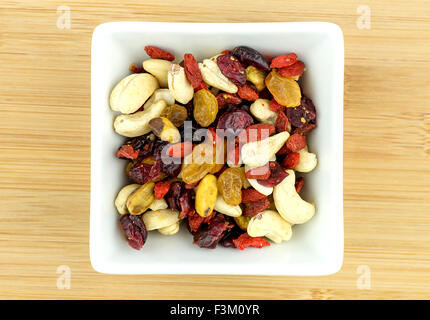 Gemischten Früchten und Nüssen in Schüssel auf hölzernen Hintergrund weiß Stockfoto
