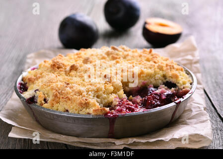 Plum Krümel Torte in Pfanne auf hölzernen Hintergrund Stockfoto