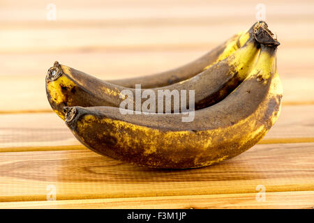 Verdorbene alte Bananen auf hölzernen Hintergrund Stockfoto