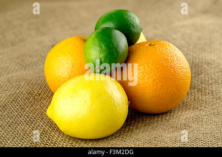 Limetten, Orangen und Zitronen in Stapeln auf Bauernhof frische hessische Tasche Stockfoto