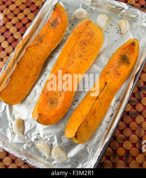 Orange Aquash auf Aluminium bedeckt Tablett mit Knoblauch Stockfoto