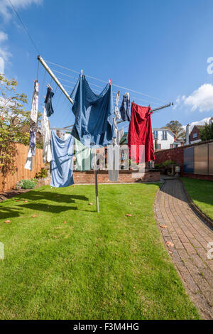 Waschen auf einer Linie rotory Tücher in einem Garten hinter dem Haus. Stockfoto