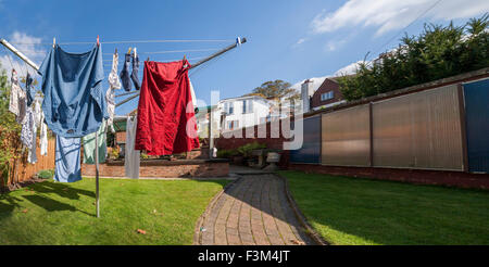 Waschen auf einer Linie rotory Tücher in einem Garten hinter dem Haus. Stockfoto