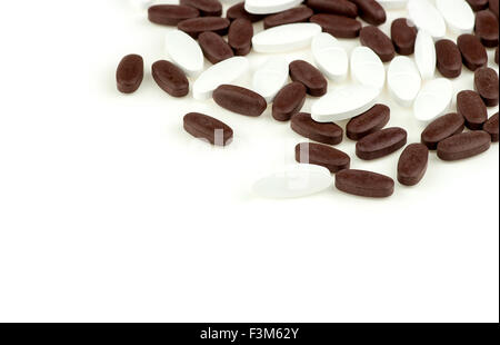 Braune und weiße Pille Tabletten verteilt auf weißen Hintergrund isoliert Stockfoto
