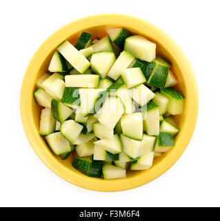 Luftaufnahme des gehackte Stücke rohen Zucchini in eine gelbe Schale isoliert auf einem weißen Hintergrund. Stockfoto