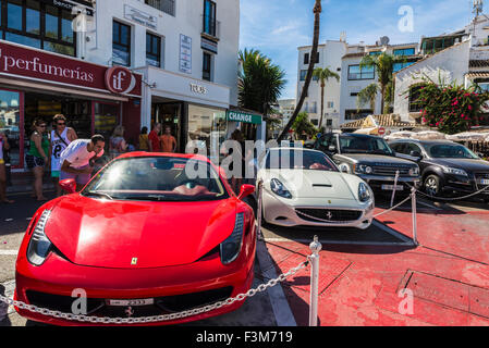 Touristen, die gerne Sport Autos geparkt, Hervorhebung einen roten Ferrari, Puerto Banus, ein Yachthafen in der Nähe von Marbella, Andalusien, Spanien Stockfoto