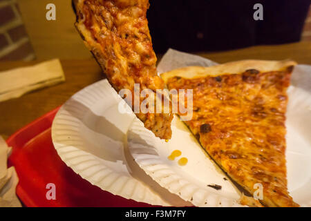 Ein hungriger Verbraucher fließt ihr Stück Pizza, entfernen das überschüssige Fett in einer Pizzeria in New York auf Freitag, 2. Oktober 2015. Eine aktuelle Studie zeigt, dass Ihre Scheibe entfetten bis zu 76 Kalorien und 4 1/2 Gramm Fett, entfernt oder bis zu zwei Pfund auf Ihre Taille jedes Jahr. Der durchschnittliche Amerikaner isst Pizza 23 Pfund jährlich. (© Richard B. Levine) Stockfoto