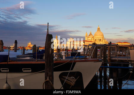 Dawn Sonnenlicht auf Basilica di Santa Maria della Salute mit Booten und Liegeplatz Pole im Vordergrund Venedig Veneto Italien Europa Stockfoto