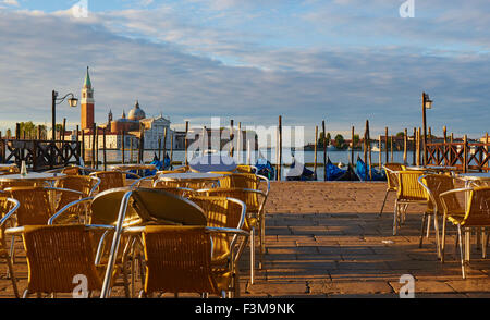 Im Freien Tische und Stühle in der Morgendämmerung mit Basilica di San Giorgio Maggiore im Hintergrund Venedig Veneto Italien Europa Stockfoto