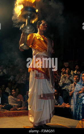 Ein junger Brahmane Priester führt Abend Aarti Zeremonie in der Nähe von brennenden Ghat (Manikarnika Ghat) am Ganges in Varanasi, Indien Stockfoto