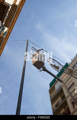 Elektriker bleibt auf Hubarbeitsbühnen und Reparaturen elektrischer Stadt Dekoration Stockfoto