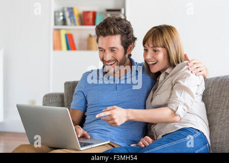 Glücklich Erfolg junges Paar mit Laptop auf dem Sofa im modernen Ferienwohnung. Stockfoto