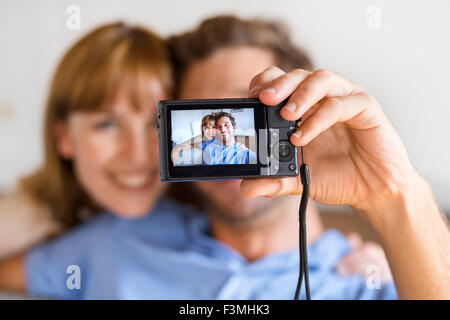 Fröhliches paar unter einem Selfie mit einer Kamera. Weißen Haus Hintergrund Stockfoto