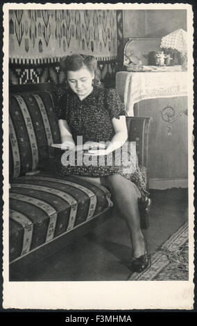 Vintage Foto. Frau sitzt auf der Couch ist ein Buch lesen. Deutschland, ca. 1946 Stockfoto