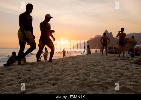 RIO DE JANEIRO, Brasilien - 21. Februar 2014: Silhouetten von Menschen Spaziergang Ipanema Strand bei Sonnenuntergang. Stockfoto