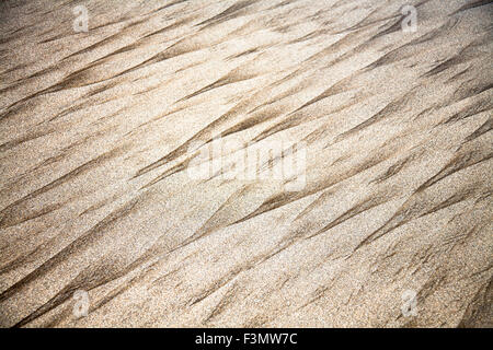 Abstrakte Muster im Sand auf einem roten Strand. Stockfoto