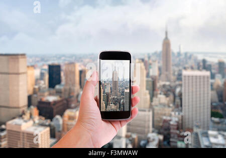 Hand mit Smartphone aufgenommenen Bilder der Skyline von New York city Stockfoto