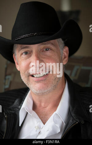 Mann lächelnd mit Cowboyhut, Nahaufnahme, natürliches Licht. Stockfoto