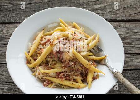 TopView Finger geformte Kartoffelknödel mit Sauerkraut und Speck Stockfoto