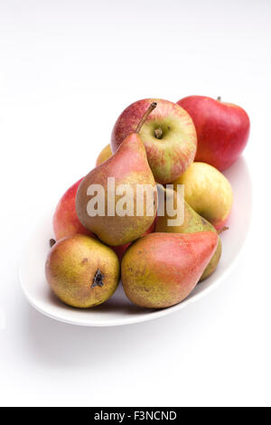 Äpfel und Birnen in einer weißen Schale. Stockfoto