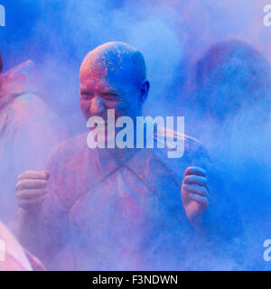 Farbläufer-Wettbewerber im Lackrennen sprangen im Oktober 2015 in Chatsworth House, Derbyshire, Großbritannien. Läufer beim Run & Dye Event. Der farbenfrohste 5-km-Markt der Welt, „Run or Dye“ im Herbst in Chatsworth. Während Läufer durch den Kurs gingen und tanzten, wurden sie auf jedem Kilometer ... in sicherer, umweltfreundlicher, pflanzlicher Pulverfarbe geduscht Verwandelt sich in eine bunte Leinwand voller Spaß. Stockfoto