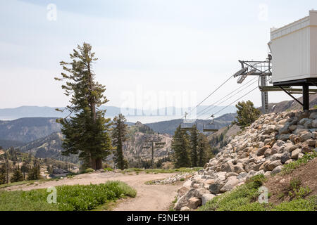 Skilift-Motor-Sitzung im Leerlauf im Sommer. Squaw Valley beschossen. Lake Tahoe und die umliegenden Berge sind am Horizont zu sehen. Stockfoto