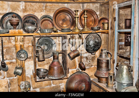 Junk-e-Shop gefüllt mit Dingen, die in den Regalen verstaubt sind. Bronza und Kupfer Utenpan-Cosils, Öfen und Kerosin-Kocher Stockfoto