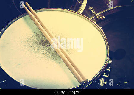 Konzeptbild Trommeln. Bild von Trommeln und Drumsticks auf Snare Drum liegen. Retro Vintage Instagram Bild. Stockfoto