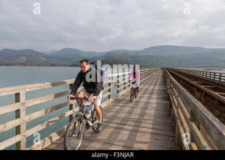 Radfahrer auf Barmouth Bridge auch bekannt als Barmouth Viadukt überquert den Mawddach Mündung, Gwynedd, Wales, UK Stockfoto