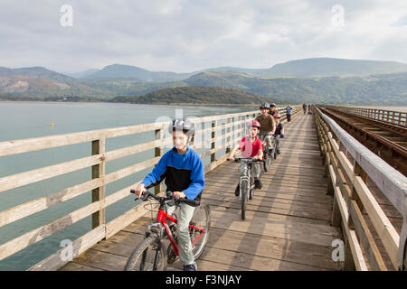 Radfahrer auf Barmouth Bridge auch bekannt als Barmouth Viadukt überquert den Mawddach Mündung, Gwynedd, Wales, UK Stockfoto