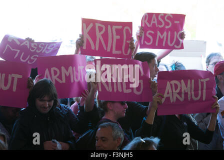 Demonstranten halten Schilder, die während der Feierlichkeiten zum 25. Jahrestag der deutschen Wiedervereinigung in Frankfurt Am Main, Deutschland, 3. Oktober 2015 "Krieg" (Krieg), "Rassismus" (Rassismus), "Armut" (Armut) zu lesen. Foto: ARNE DEDERT/dpa Stockfoto