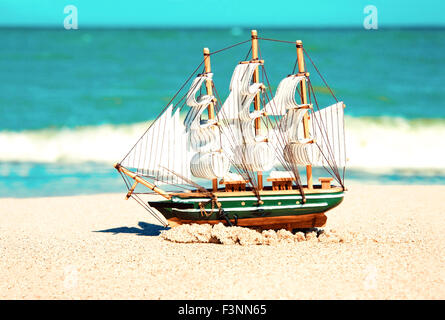 Souvenir-Konzeptbild. Modell des Schiffes in den Sand am Meer. Stockfoto