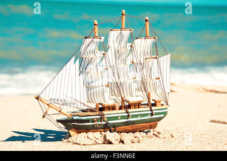 Souvenir-Konzeptbild. Modell des Schiffes in den Sand am Meer. Stockfoto