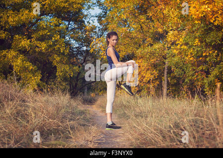 Junge schöne Mädchen Sport in den herbstlichen Wald bei Sonnenuntergang Stockfoto