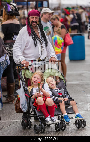 Tybee Island, Georgia. 10. Oktober 2015. Kostümierten Piraten Vater schiebt seine müde Piraten Kinder im Kinderwagen während des jährlichen dreitägigen Tybee Island Pirate Festival 10. Oktober 2015 in Tybee Island, Georgia. Stockfoto