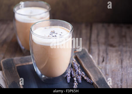 Heißen Latte in großen doppelwandigen Gläsern mit getrocknetem Lavendel Stockfoto