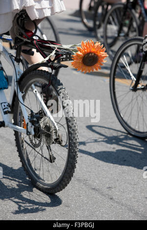 Das rückseitige Rad ein Fahrrad und eine bunte Blume auf dem Fahrradträger während der jährlichen Fahrrad-Protest in Athen, Griechenland. Stockfoto