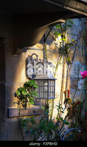 Alten altmodischen außen Licht von der Sonne beschienen, auf einer Hütte in Stanton Dorf, Cotswolds, Gloucestershire, England Stockfoto