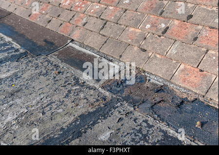 Scheitern und der sich verschlechternden Flachdach bis Eröffnung gemeinsame Risse untergegangenen Dach alte und undichte untergegangenen Oberfläche Bitumen fühlte geknackt Stockfoto