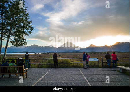 Touristen genießen Sie Blick auf den Sonnenuntergang von der Terrasse des berühmten & historischen Jackson Lake Lodge; Grand Teton Nationalpark; Teton Range Stockfoto