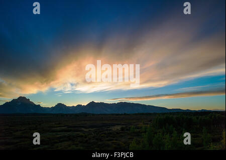 Touristen genießen Sie Blick auf den Sonnenuntergang von der Terrasse des berühmten & historischen Jackson Lake Lodge; Grand Teton Nationalpark; Teton Range Stockfoto