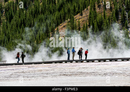 Die Besucher des Parks gehen auf der Promenade entlang Grand Bildobjekte Frühling, Midway Geyser Basin, Yellowstone-Nationalpark, Wyoming, USA Stockfoto