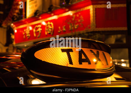 Das ikonische schwarze Taxi-Mietschild in Chinatown, Soho, Central London, Großbritannien Stockfoto