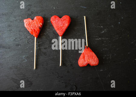 Wassermelone-Pops. Wassermelone-Scheiben in Herz-Form-Stücke schneiden. Stockfoto