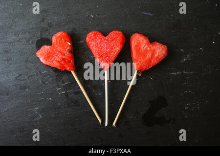 Wassermelone-Pops. Wassermelone-Scheiben in Herz-Form-Stücke schneiden. Stockfoto