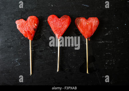 Wassermelone-Pops. Wassermelone-Scheiben in Herz-Form-Stücke schneiden. Stockfoto